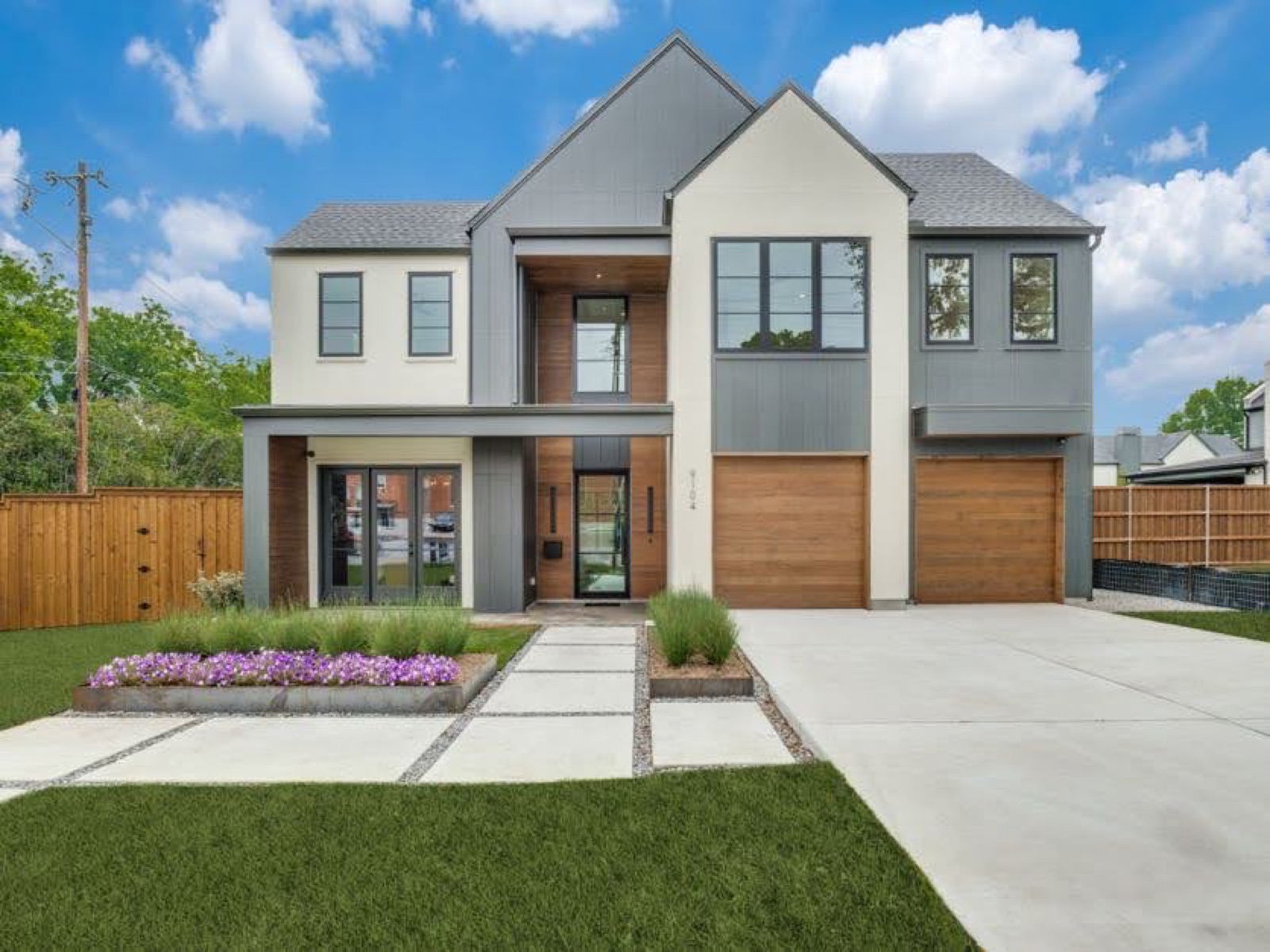 Contemporary home with black steel windows, steel patio doors, and a steel entry with wood cladding.