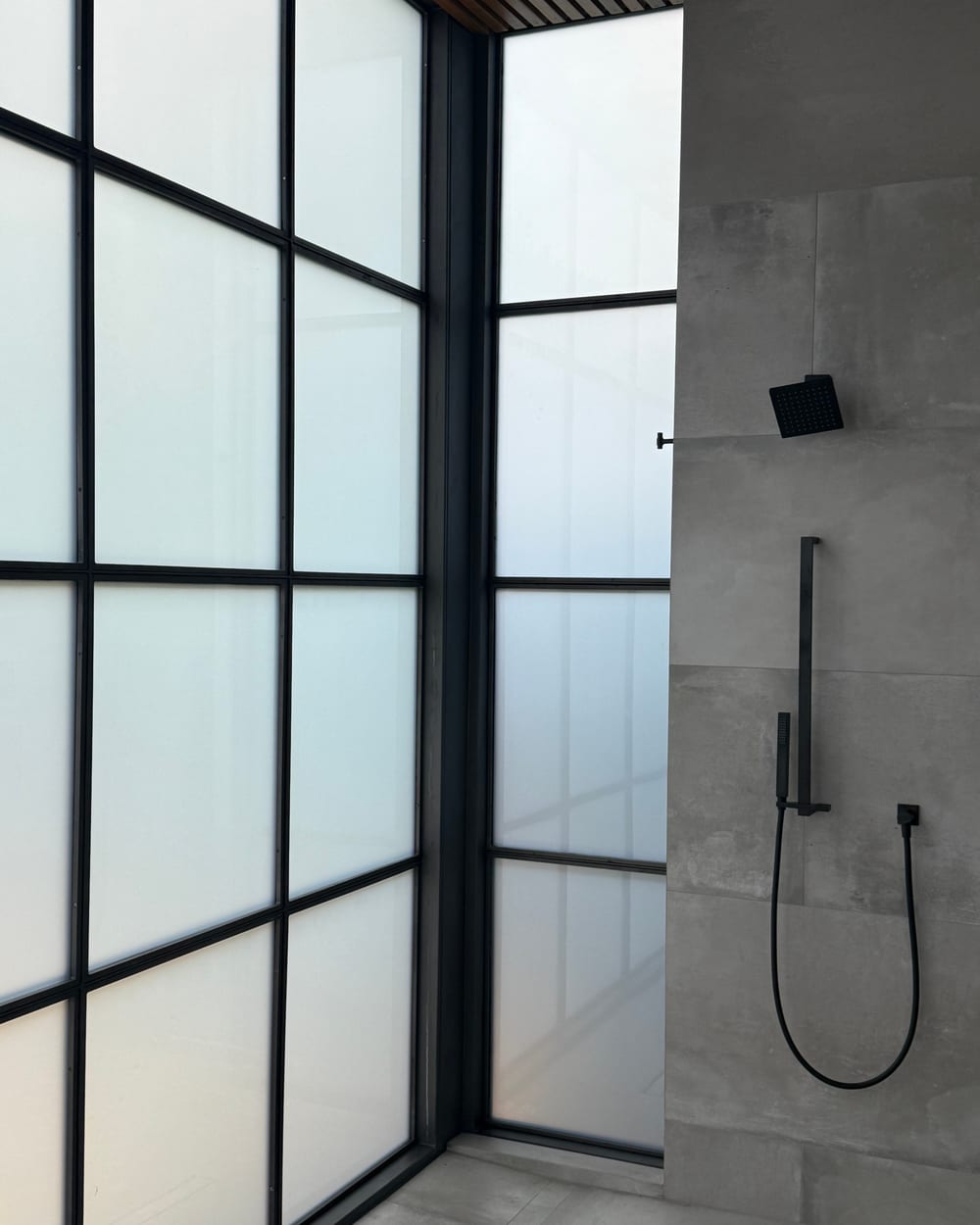 Steel-framed smart glass shower with a clean finished surface and no visible wiring or conduit