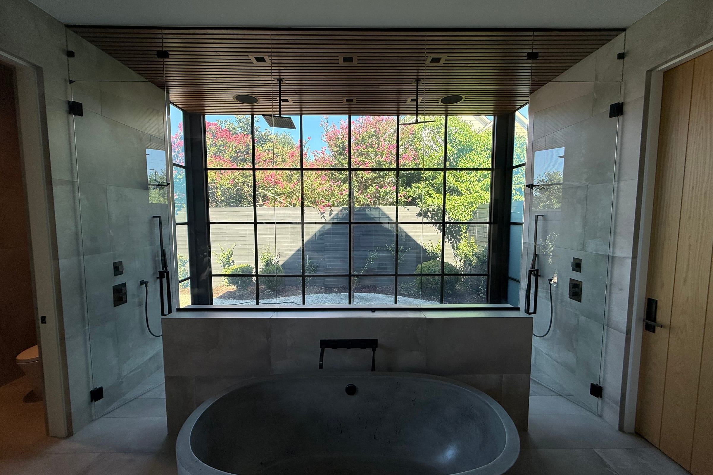 Master bathroom with steel-framed switchable smart glass windows and no visible wiring