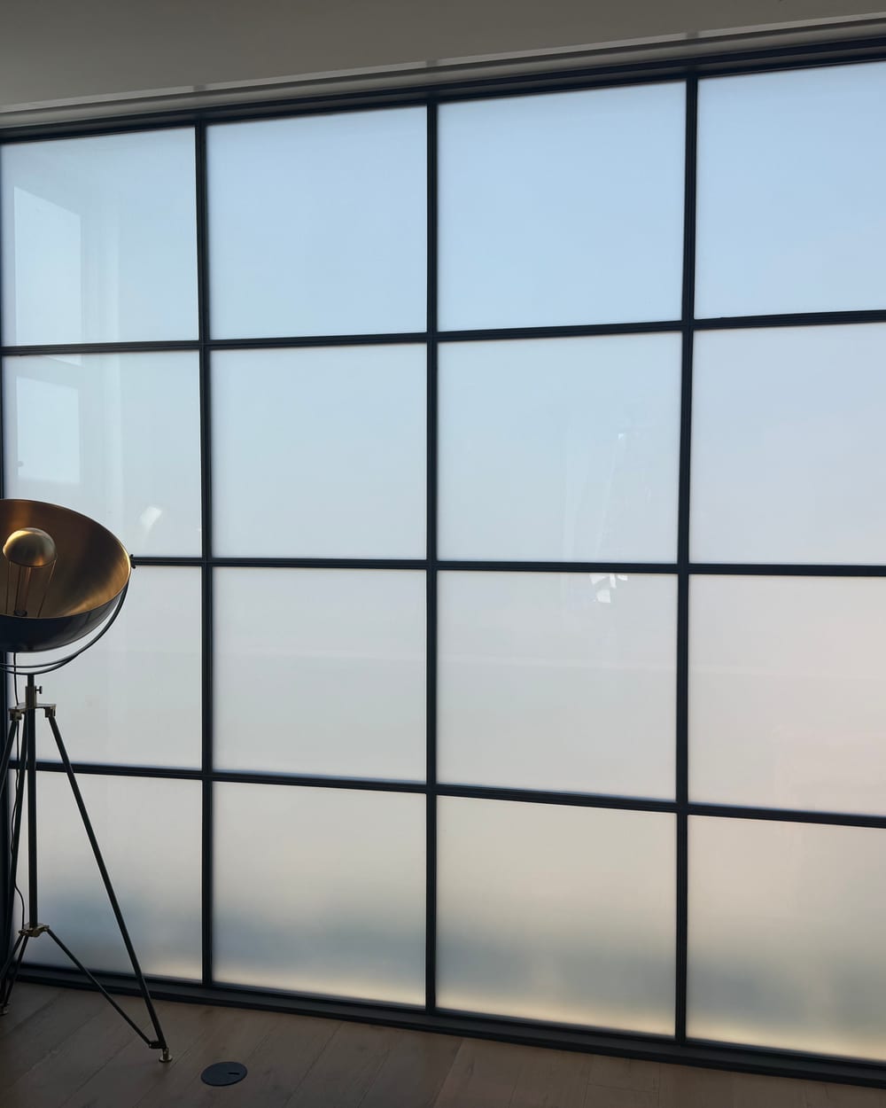 Frosted steel-framed smart glass wall in an office, ready to double as a projection surface